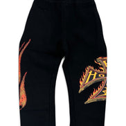 Black sweatpants with orange and yellow flame graphics on the left leg and right leg, featuring an elastic waistband.