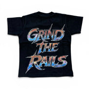 A black short-sleeve t-shirt with a large graphic print on the back reading 'GRIND THE RAILS' in a stylized metallic font with blue, orange, and silver colors, shown against a plain white background.