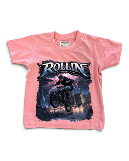 A pink short-sleeve kids' t-shirt featuring a large graphic print of a mountain biker in mid-air with the word 'ROLLIN' in stylized lettering above, set against a plain white background.