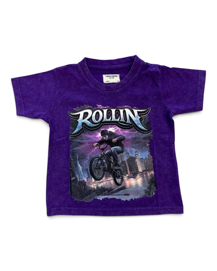 A purple short-sleeve kids' t-shirt featuring a large graphic print of a BMX rider with the word 'ROLLIN'' in stylized lettering, displayed flat against a white background.