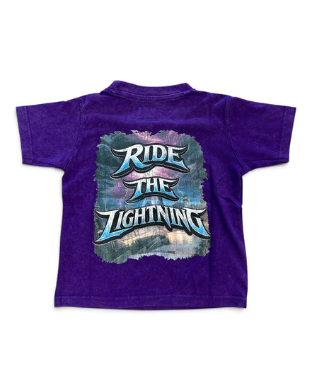 A purple short-sleeve t-shirt shown from the back, featuring a large graphic print with the text 'RIDE THE LIGHTNING' in stylized blue and white lettering over a smoky, lightning-themed background.