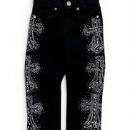 Black denim pants featuring large silver rhinestone cross designs on both legs, shown against a plain white background.