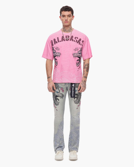 Person wearing a pink t-shirt with graphic design and patterned pants on a white background