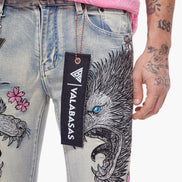 Close-up of jeans with a Valabasas tag and tattooed arm.
