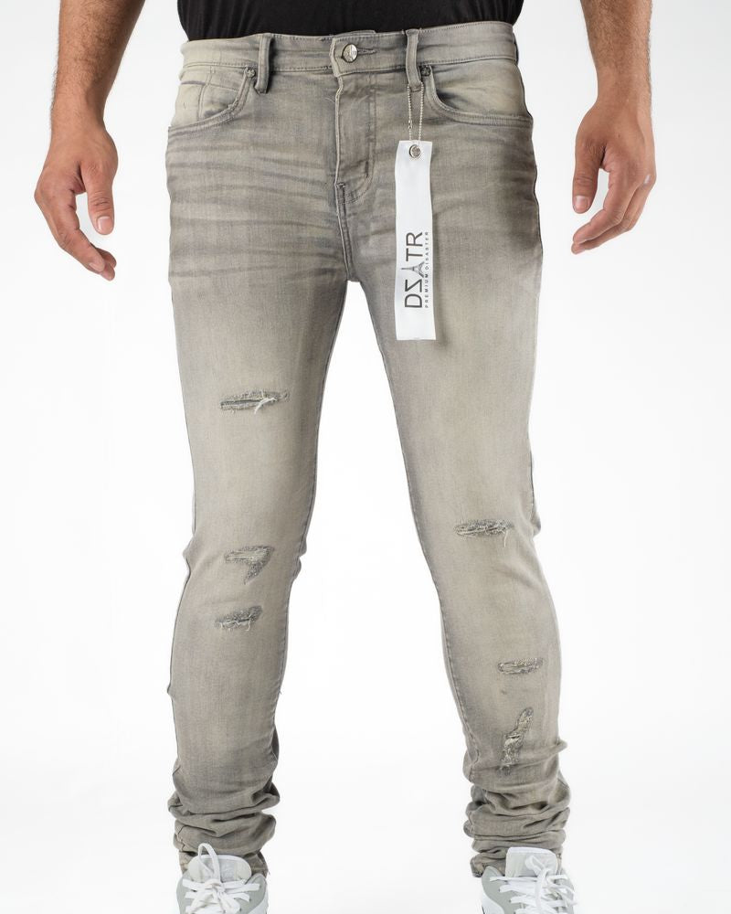 Gray distressed jeans with a brand tag on a white background