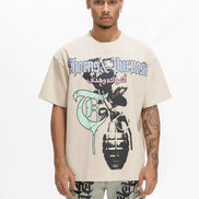 Person wearing a beige t-shirt with graphic design and text, standing against a white background