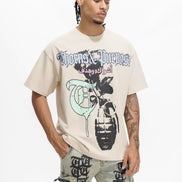 Person wearing a beige t-shirt with graphic design and text, standing against a white background