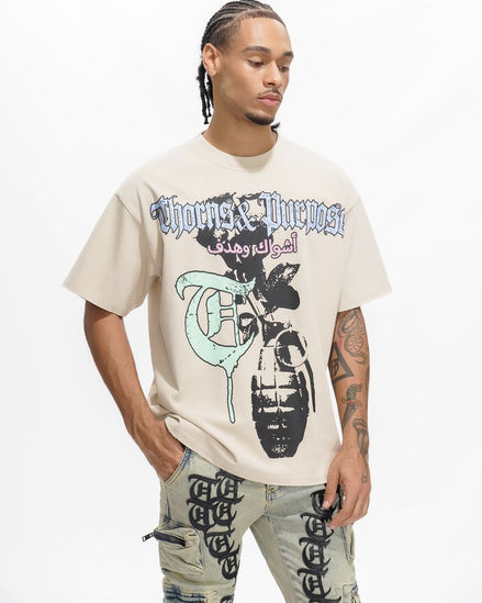 Person wearing a beige t-shirt with graphic design and text, standing against a white background