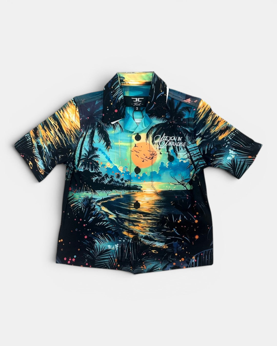 Short-sleeve shirt with tropical design featuring palm trees and a sunset on a white background