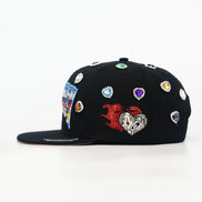 Black cap with colorful embellishments on a white background