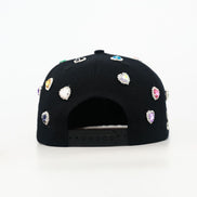 Black cap with colorful gemstones on a white background