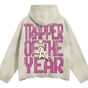 Beige hoodie with pink text 'TRAPPER OF THE YEAR' on a white background