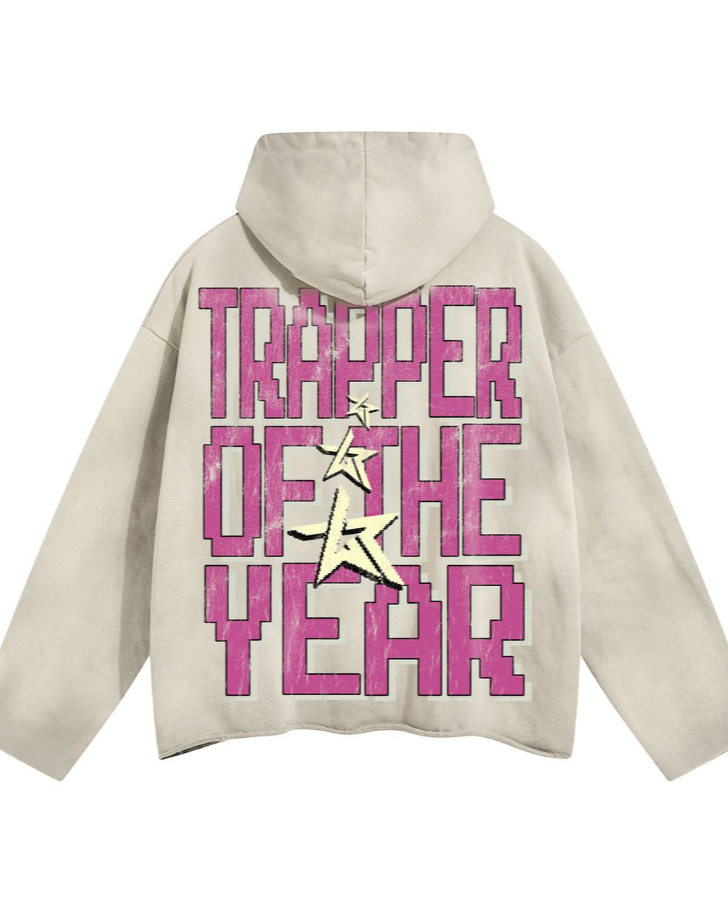 Beige hoodie with pink text 'TRAPPER OF THE YEAR' on a white background