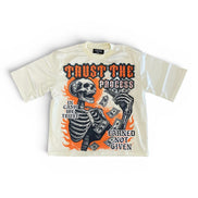 Beige t-shirt with a skeleton graphic and text on a white background