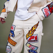 White pants with colorful patches and logos on a neutral background