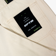 Beige pants with a black label featuring 'EPTM' branding on a white background