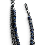 A double-strand chain strap featuring one dark gunmetal chain and one chain embellished with textured blue beads, both finished with silver-tone lobster clasp ends, shown on a plain white background.