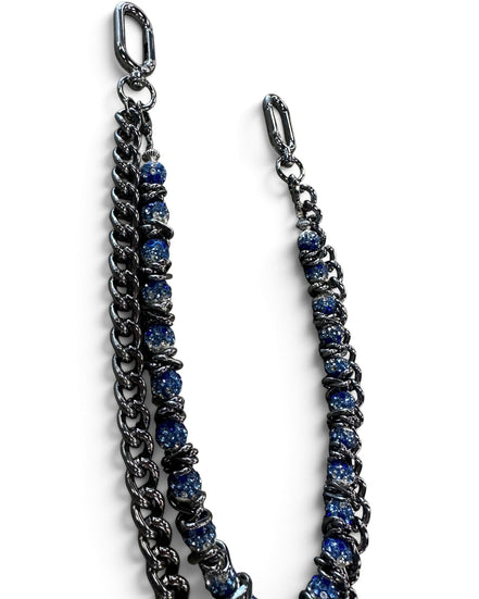 A double-strand chain strap featuring one dark gunmetal chain and one chain embellished with textured blue beads, both finished with silver-tone lobster clasp ends, shown on a plain white background.