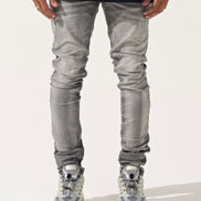 Person wearing gray jeans and black shirt on a white background