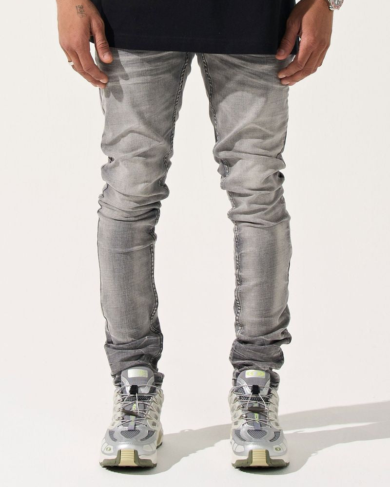 Person wearing gray jeans and black shirt on a white background