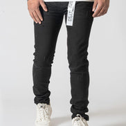 Person wearing black jeans with a visible brand label on a white background