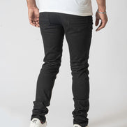 Person wearing black pants and white sneakers on a white background