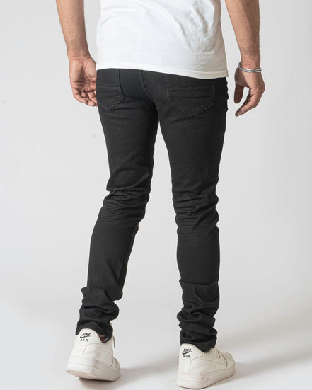 Person wearing black pants and white sneakers on a white background