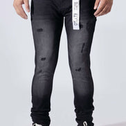 A person wearing slim-fit black distressed jeans with a white vertical Dst. Hy.