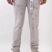 Person wearing light gray distressed jeans with a visible brand label on a white background