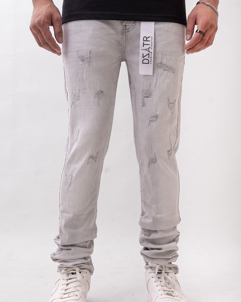 Person wearing light gray distressed jeans with a visible brand label on a white background