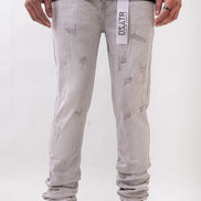 Person wearing light gray distressed jeans with a visible brand label on a white background