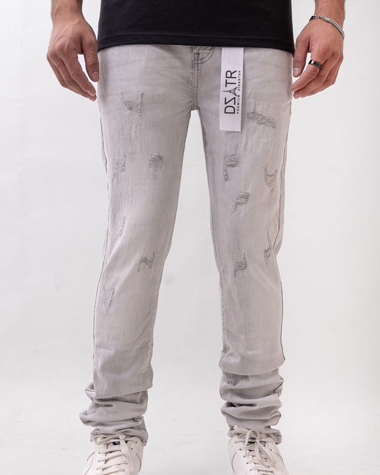 Person wearing light gray distressed jeans with a visible brand label on a white background