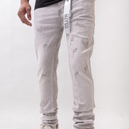 Person wearing light gray distressed jeans with a visible brand logo on a white background