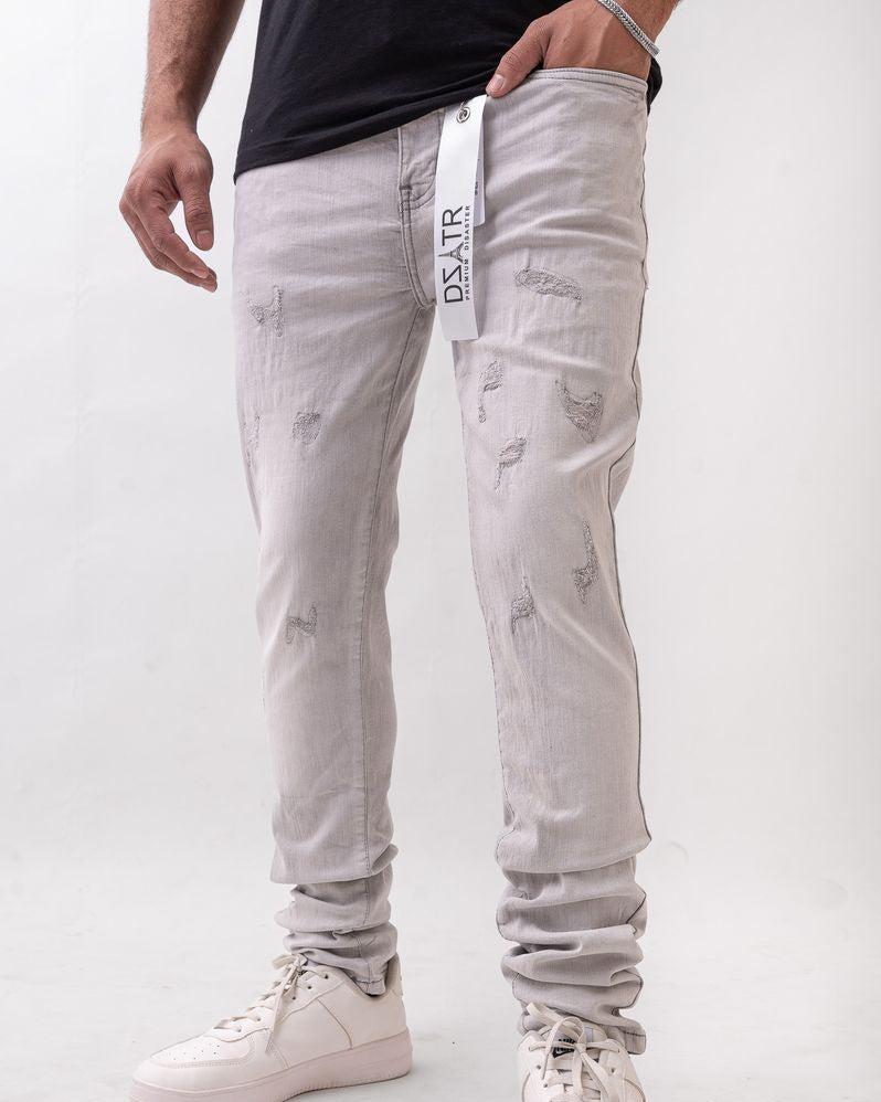 Person wearing light gray distressed jeans with a visible brand logo on a white background