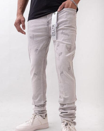 Person wearing light gray distressed jeans with a visible brand logo on a white background