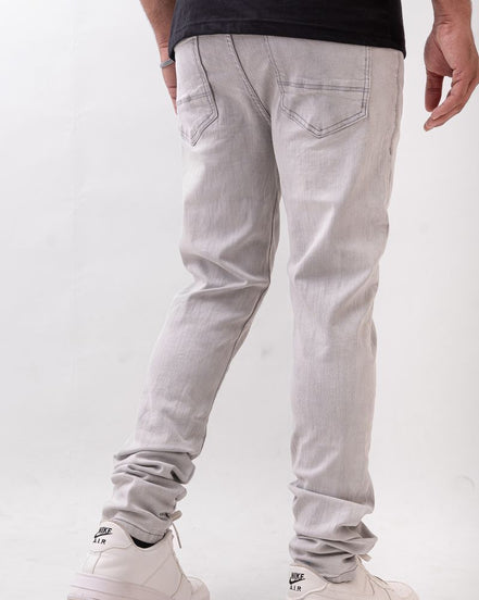Person wearing light gray pants and white sneakers on a white background