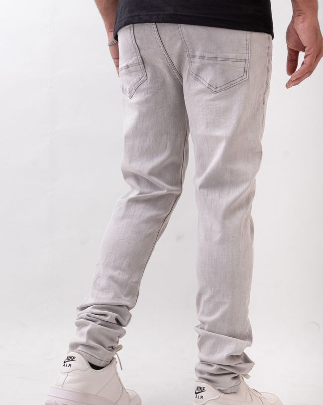 Person wearing light gray pants and white sneakers on a white background