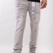 Person wearing light gray jeans with a visible brand label on a white background