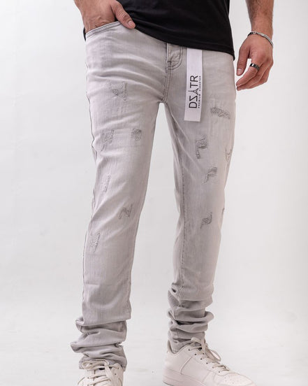 Person wearing light gray jeans with a visible brand label on a white background