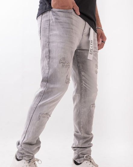 Gray distressed jeans with a brand tag on a white background