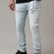 Light blue jeans with a brand label worn by a person on a gray background