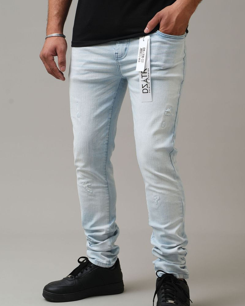 Light blue jeans with a brand label worn by a person on a gray background