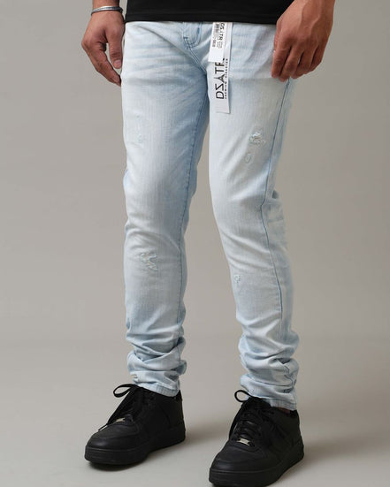 Person wearing light blue jeans with a brand logo on a gray background