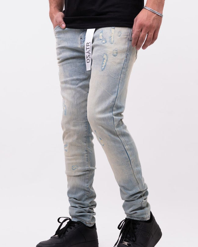 Person wearing light blue distressed jeans with a brand logo on a white background