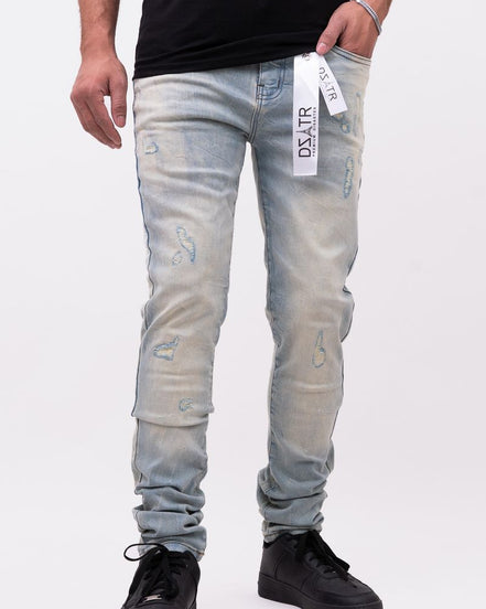 Person wearing light blue distressed jeans with a brand label on a white background