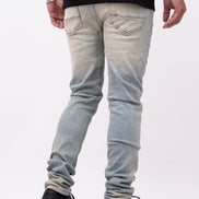 Person wearing light blue jeans and black shoes on a white background