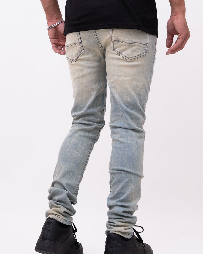 Person wearing light blue jeans and black shoes on a white background