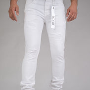 Person wearing white jeans with a brand tag on a gray background