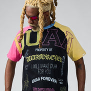 Person wearing a black t-shirt with colorful text and graphics on a gray background