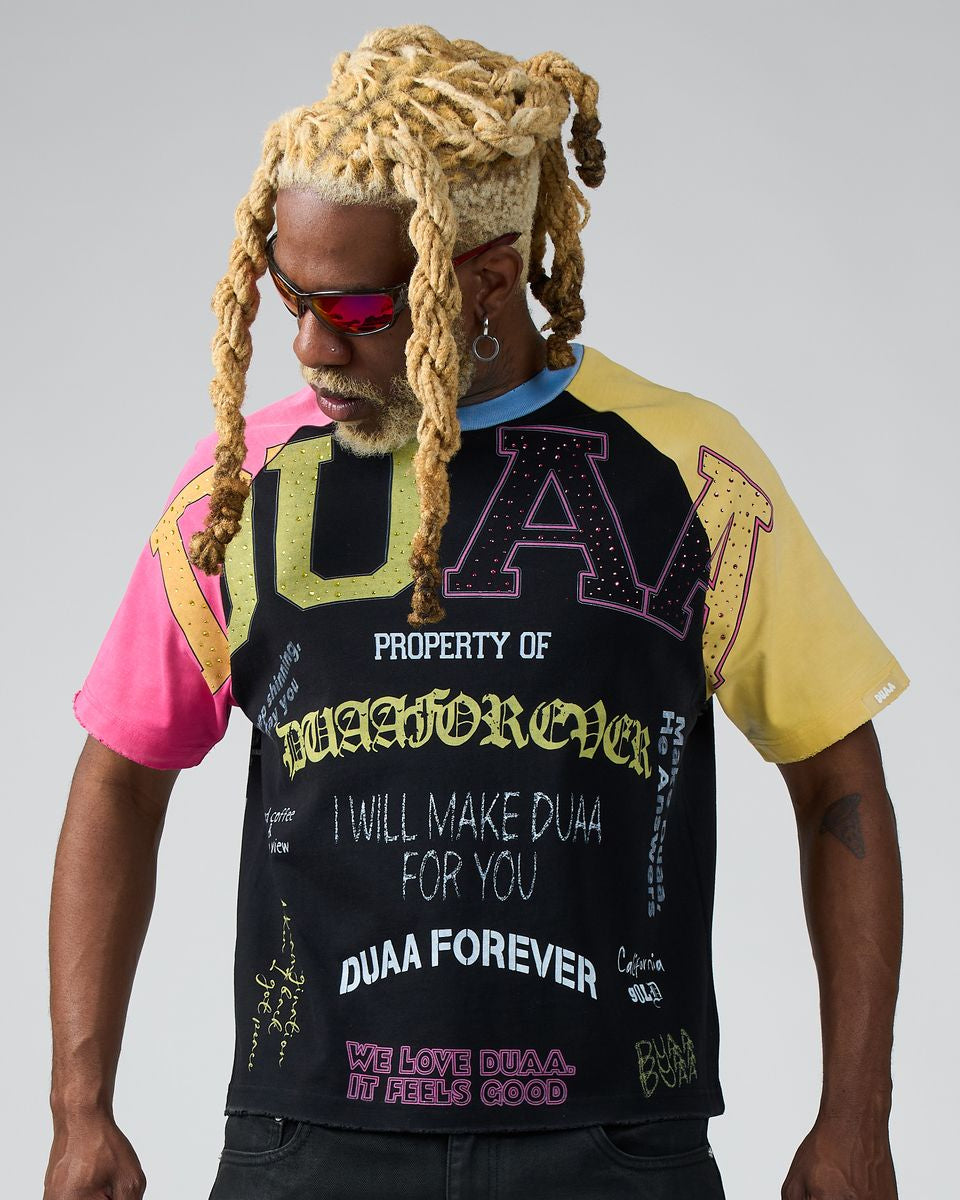 Person wearing a black t-shirt with colorful text and graphics on a gray background